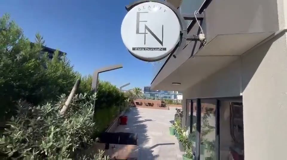 Sokaktan gorunen EN Beauty Studio tabelasi, altinda zeytin agacli teras ve giris kapisi